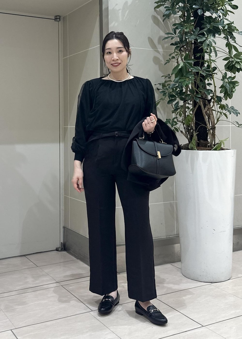 ブラック系のニット/セーター、ブラック系のローファー、ブラック系のノーカラージャケットを着用したレディースの冬コーディネートの8枚目の写真