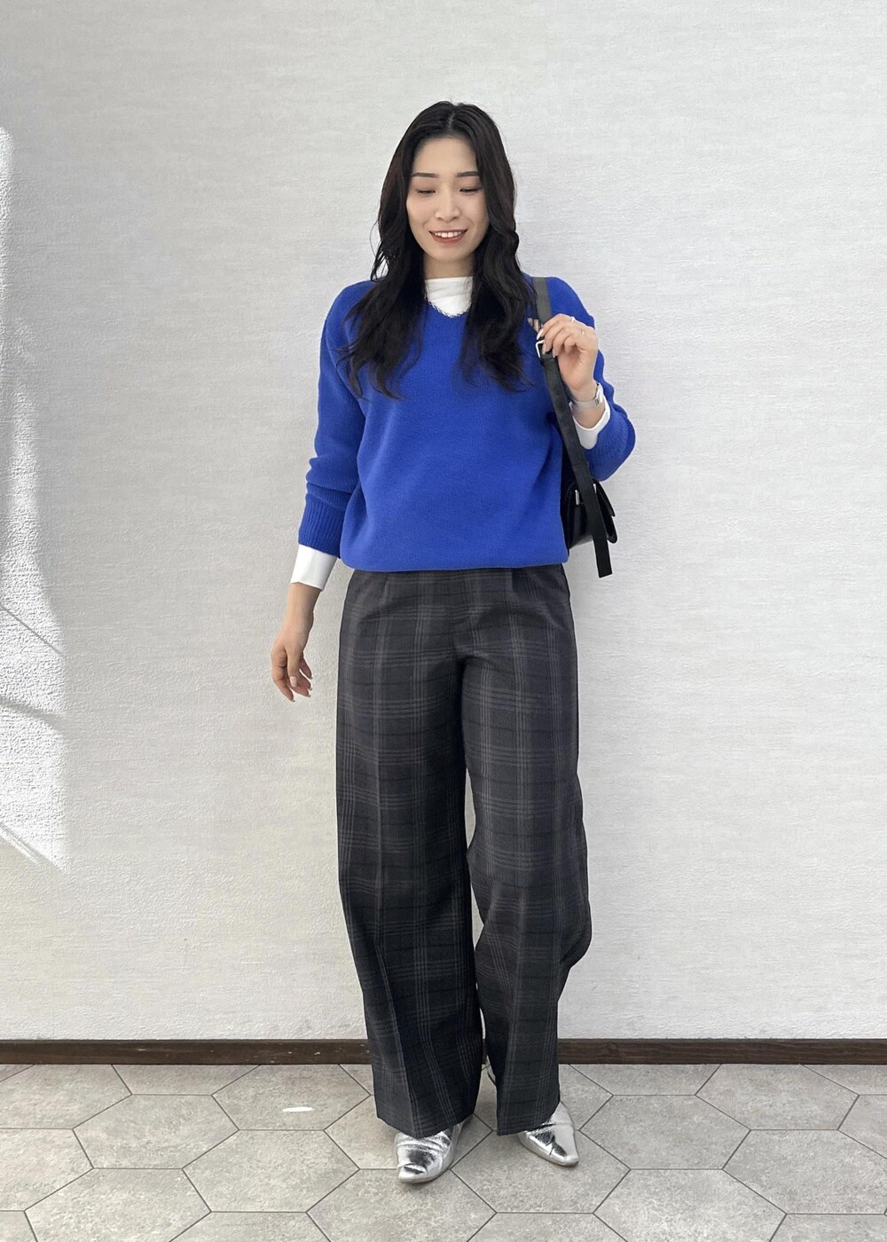 ブラック系のショルダーバッグ、ブルー系のニット/セーター、ホワイト系のTシャツ/カットソーを着用したレディースの秋コーディネートの4枚目の写真