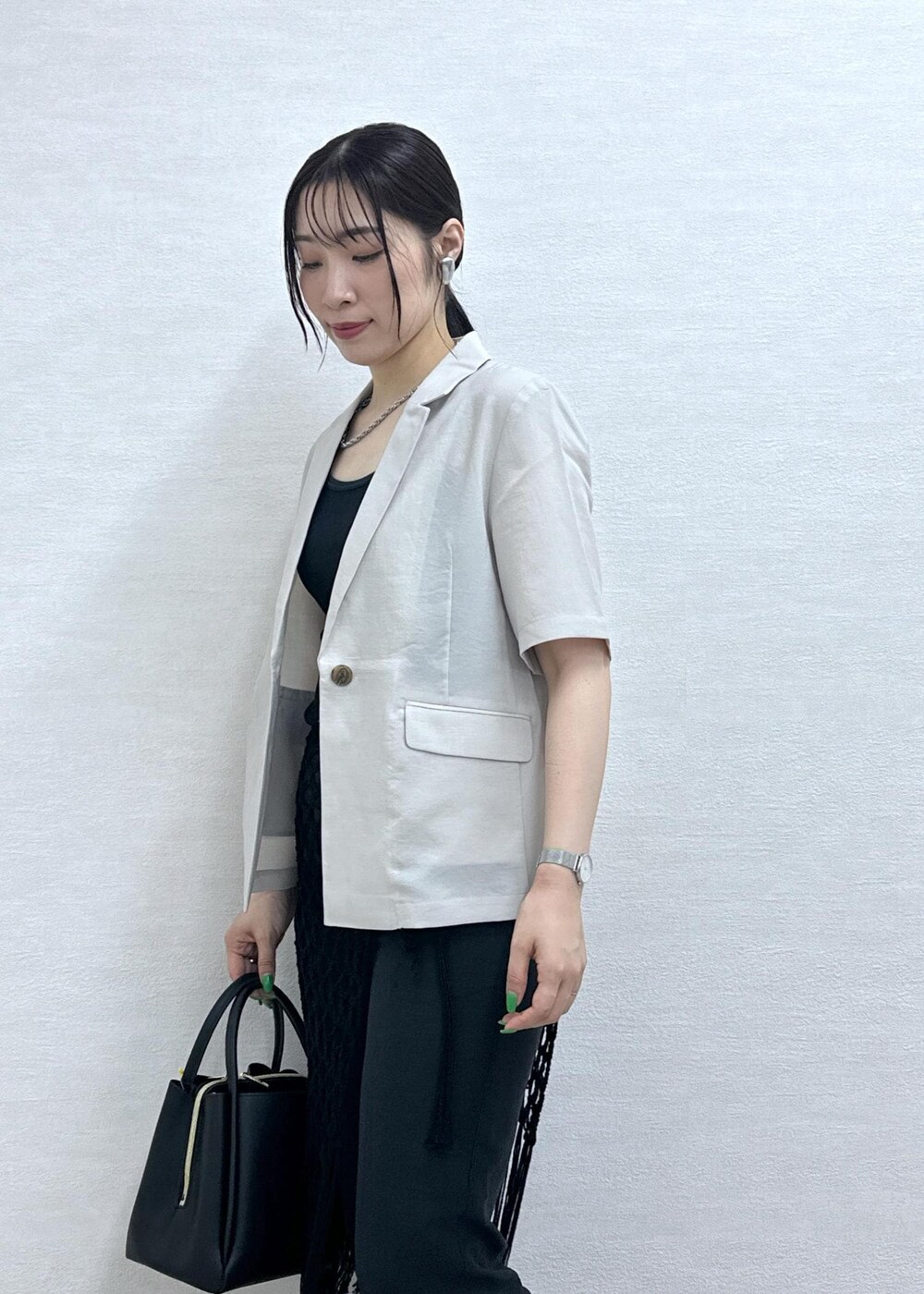 ブラック系のショルダーバッグ、ベージュ系のテーラードジャケット、グレー系のその他パンツを着用したレディースの夏コーディネートの7枚目の写真