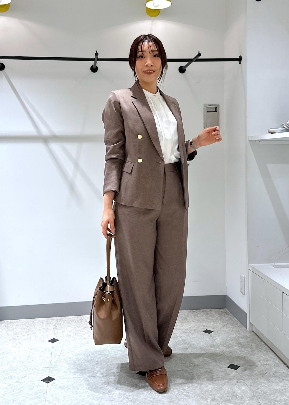 イエロー系のローファー、ブラウン系のショルダーバッグ、ホワイト系のシャツ/ブラウスを着用したレディースの夏コーディネートの3枚目の写真