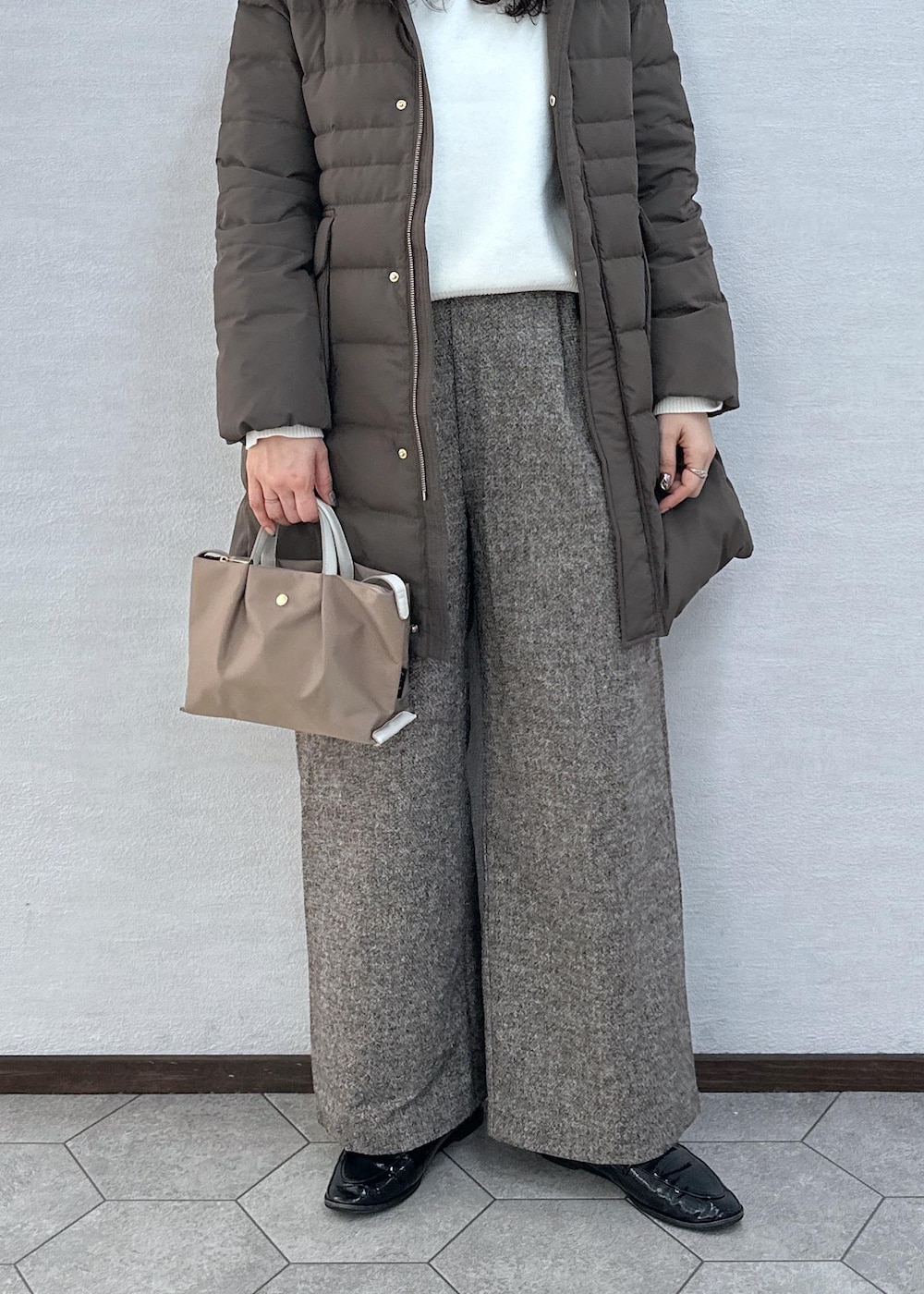 ブラウン系のダウンジャケット/コート、ブラウン系のその他パンツ、ブラウン系のショルダーバッグを着用したレディースの冬コーディネートの7枚目の写真