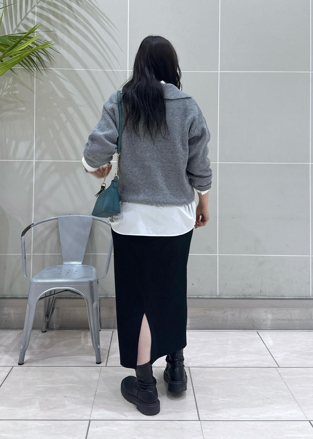 グレー系のニット/セーター、ブラック系のスカート、ホワイト系のシャツ/ブラウスを着用したレディースの秋コーディネートの4枚目の写真