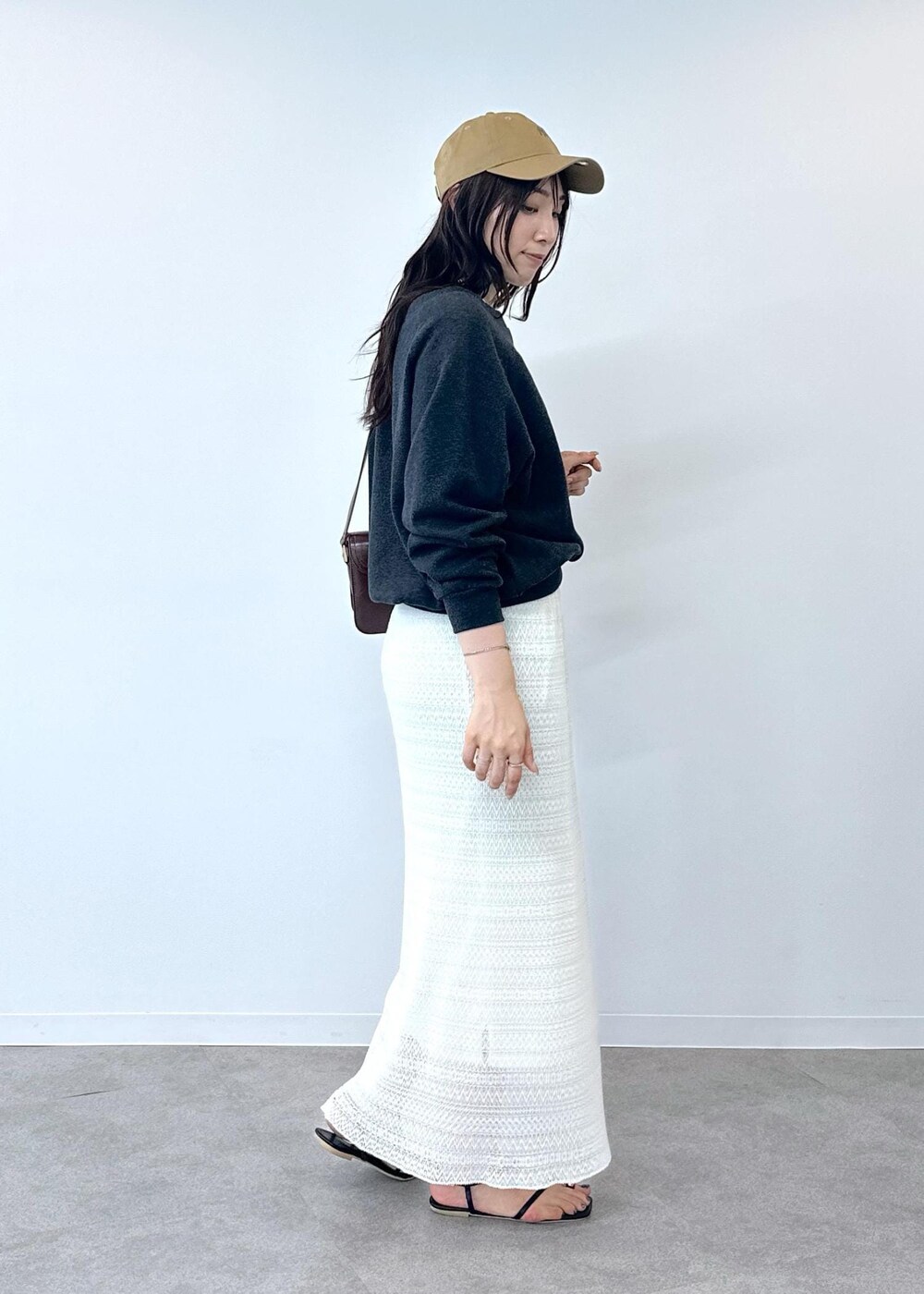 ブラック系のサンダル、ホワイト系のスカート、レッド系のショルダーバッグを着用したレディースの夏コーディネートの6枚目の写真