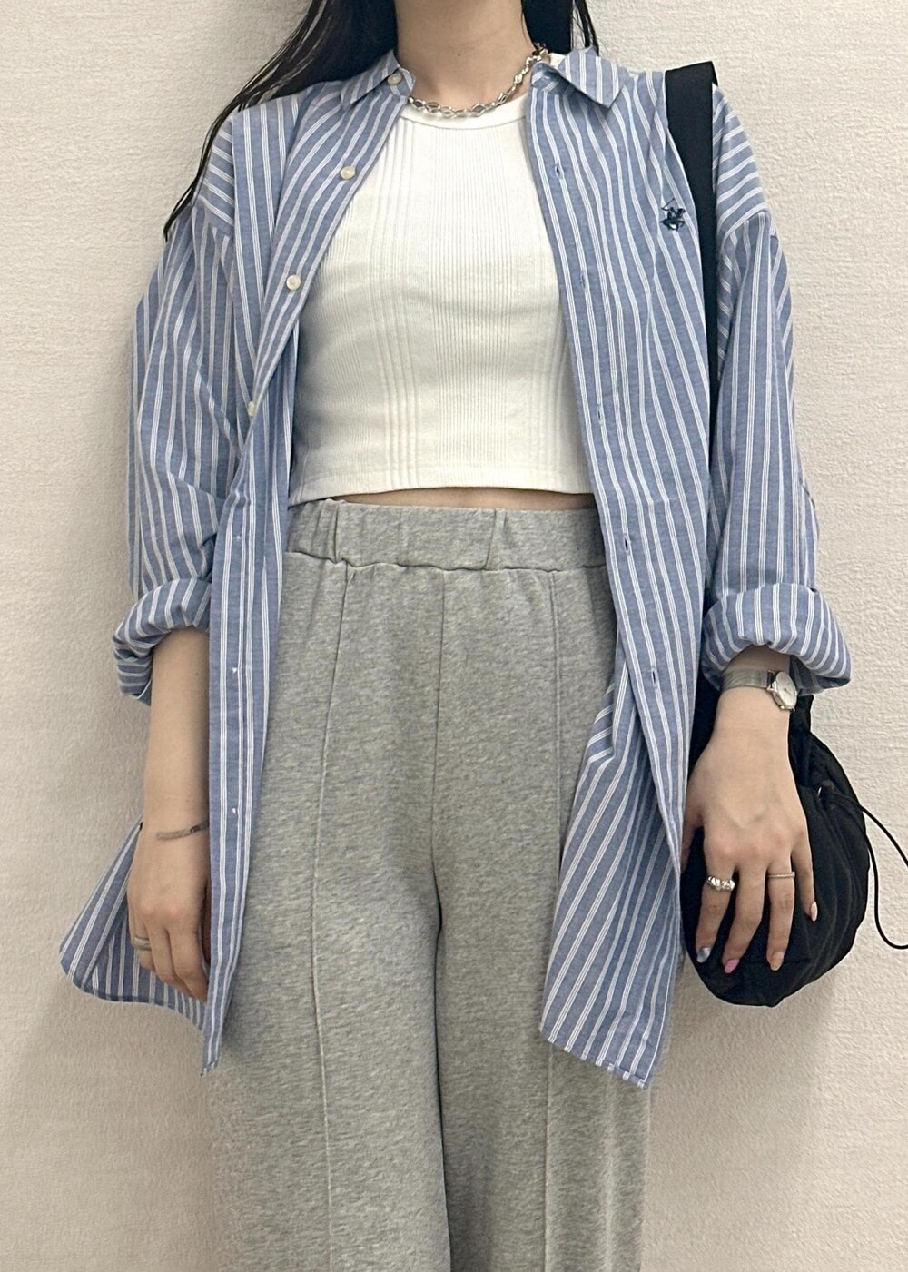 ブラック系のサンダル、ブラック系のショルダーバッグ、ホワイト系のタンクトップを着用したレディースの春コーディネートの5枚目の写真