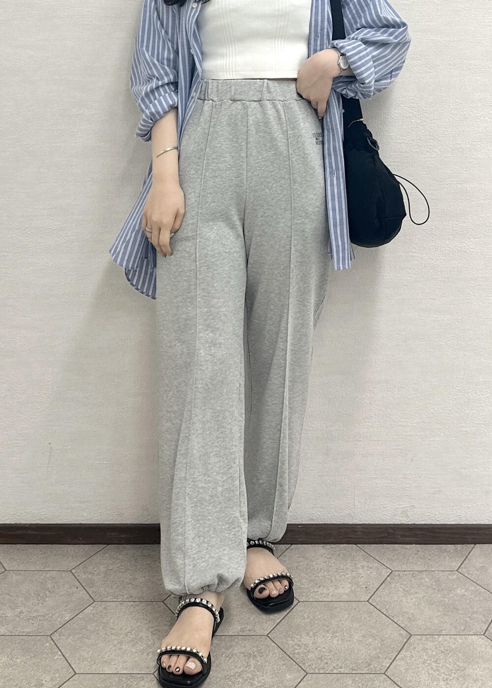 ブラック系のサンダル、ブラック系のショルダーバッグ、ホワイト系のタンクトップを着用したレディースの春コーディネートの6枚目の写真