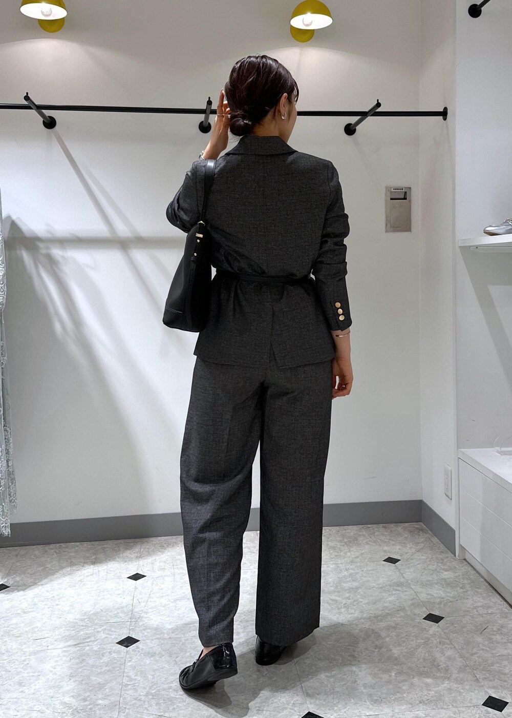 ブラック系のタンクトップ、グレー系のテーラードジャケット、グレー系のスラックスを着用したレディースの夏コーディネートの5枚目の写真