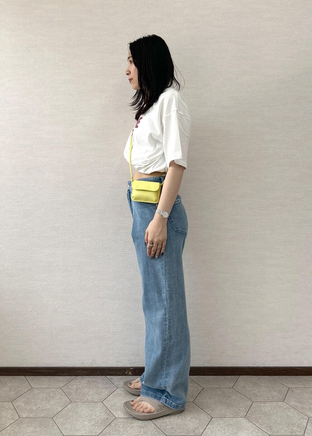 イエロー系のショルダーバッグ、ブルー系のデニムパンツ、ホワイト系のTシャツ/カットソーを着用したレディースの夏コーディネートの4枚目の写真