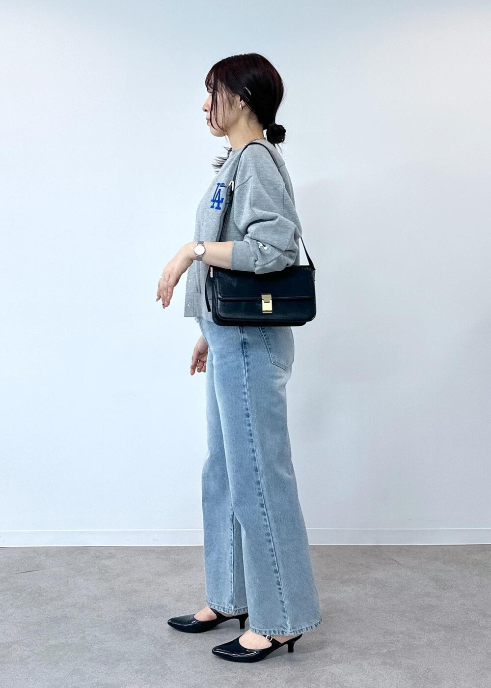 グレー系のデニムパンツ、ホワイト系のタンクトップ、ブラック系のショルダーバッグを着用したレディースの夏コーディネートの7枚目の写真