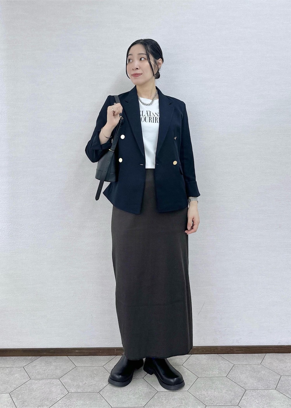 ホワイト系のTシャツ/カットソー、グレー系のスカート、ブラック系のショルダーバッグを着用したレディースの秋コーディネートの2枚目の写真