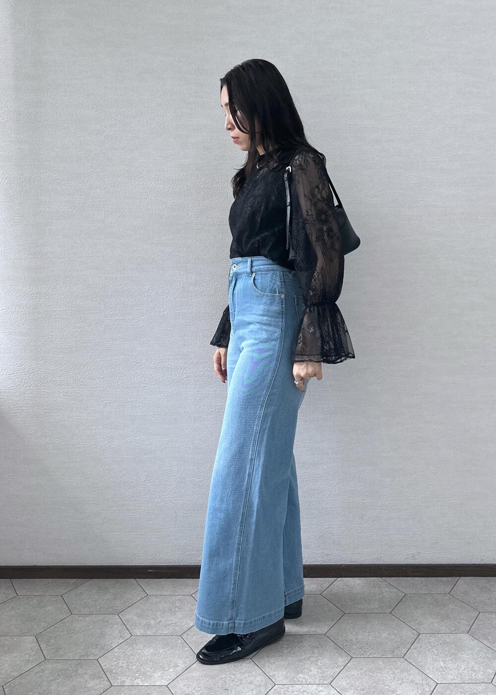 ブルー系のデニムパンツ、ブラック系のショルダーバッグ、ブラック系のシャツ/ブラウスを着用したレディースの秋コーディネートの3枚目の写真