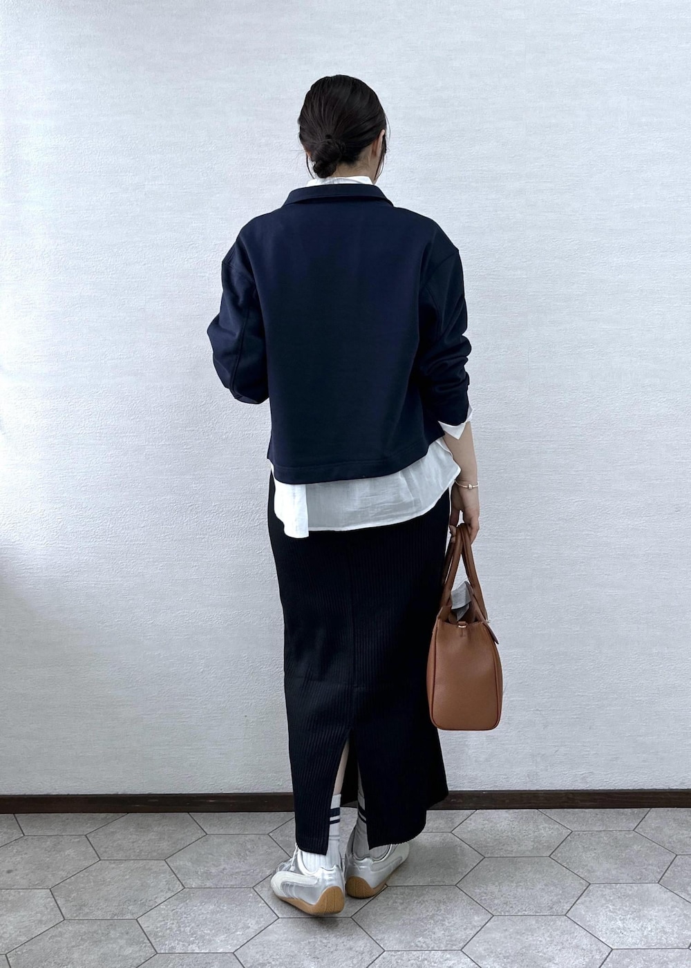 ブラック系のスカート、イエロー系のトートバッグ、ブルー系のスウェットを着用したレディースの春コーディネートの4枚目の写真