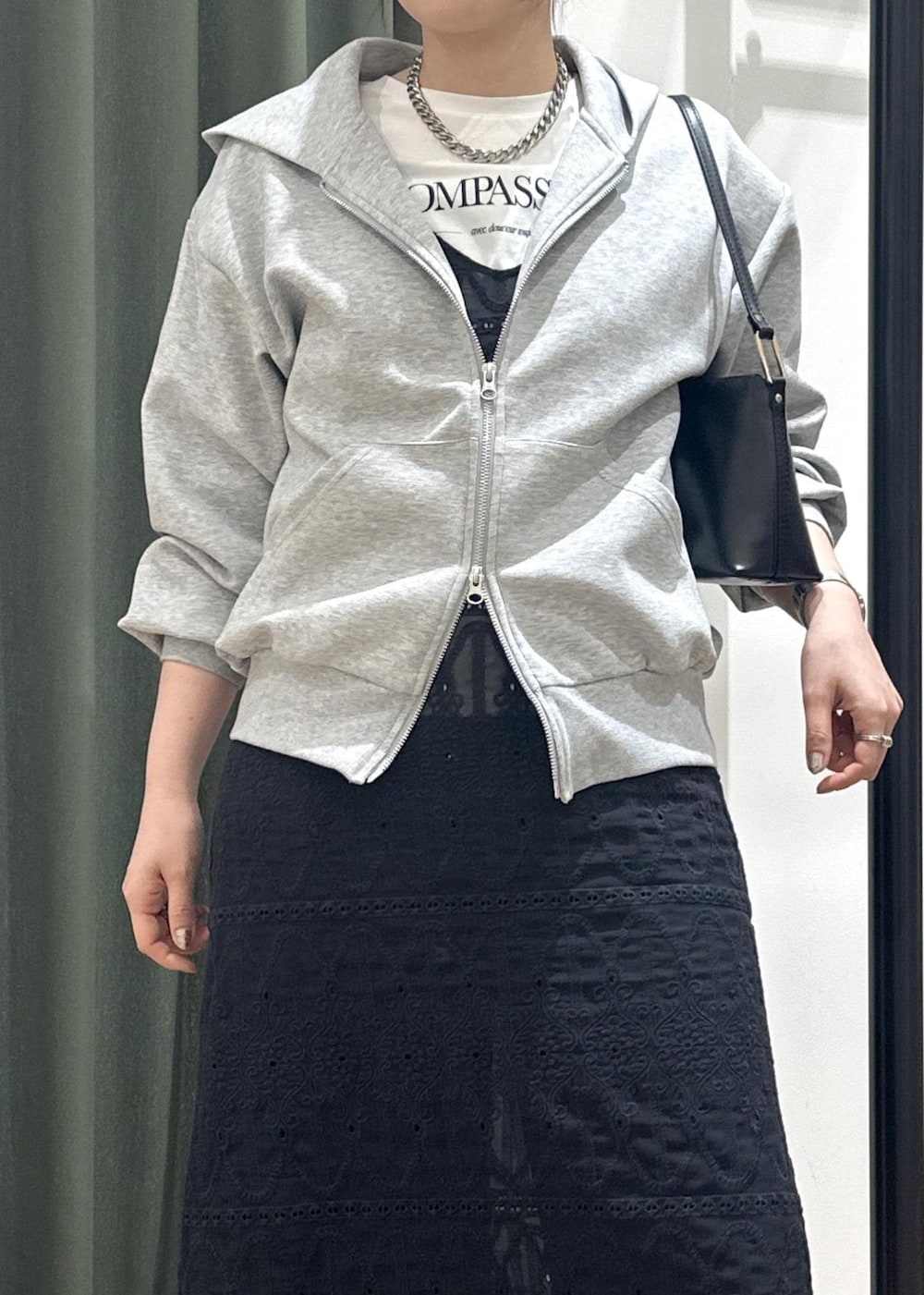 ブラック系のショルダーバッグ、ブラック系のワンピース、ホワイト系のTシャツ/カットソーを着用したレディースの春コーディネートの7枚目の写真