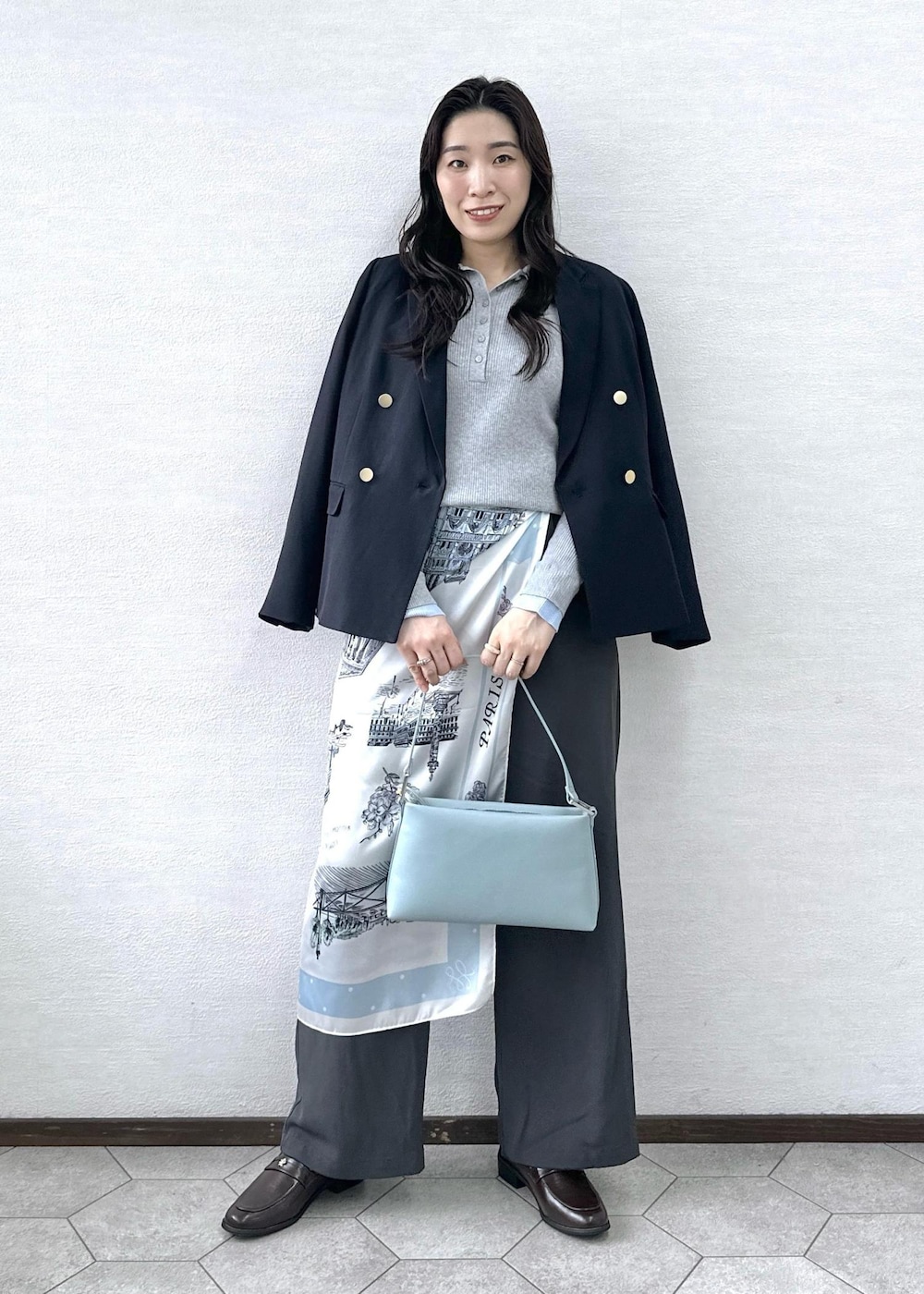 ブルー系のショルダーバッグ、ブラウン系のローファー、ブルー系のテーラードジャケットを着用したレディースの冬コーディネートの2枚目の写真