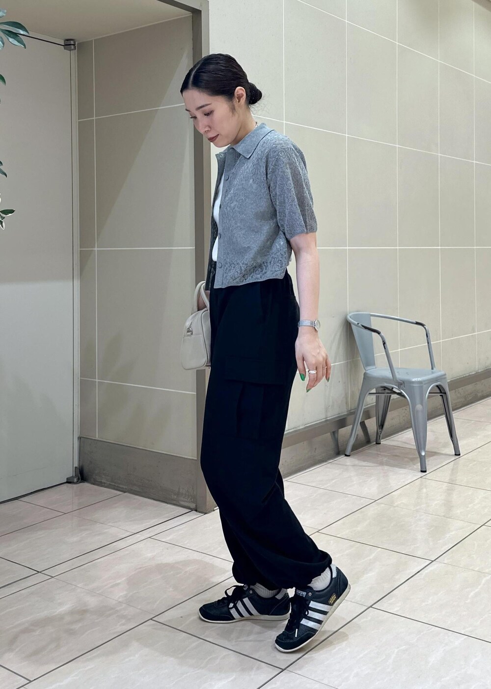 ベージュ系のボストンバッグ、ブラック系のカーゴパンツ、ホワイト系のタンクトップを着用したレディースの夏コーディネートの4枚目の写真