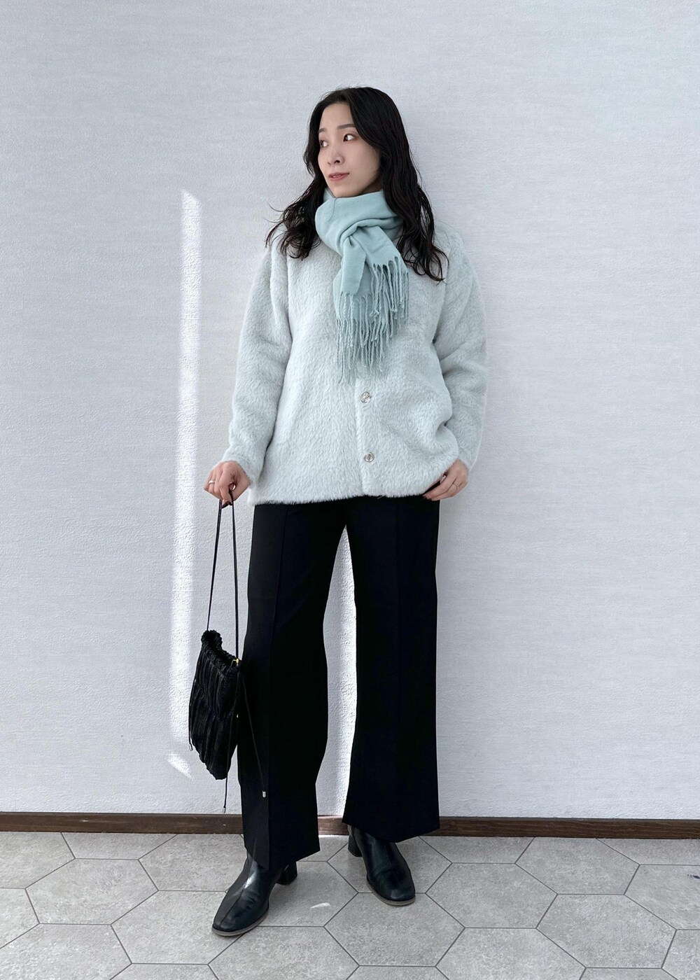 ブラック系のその他パンツ、ブラック系のブーツ、ブラック系のショルダーバッグを着用したレディースの冬コーディネートの2枚目の写真