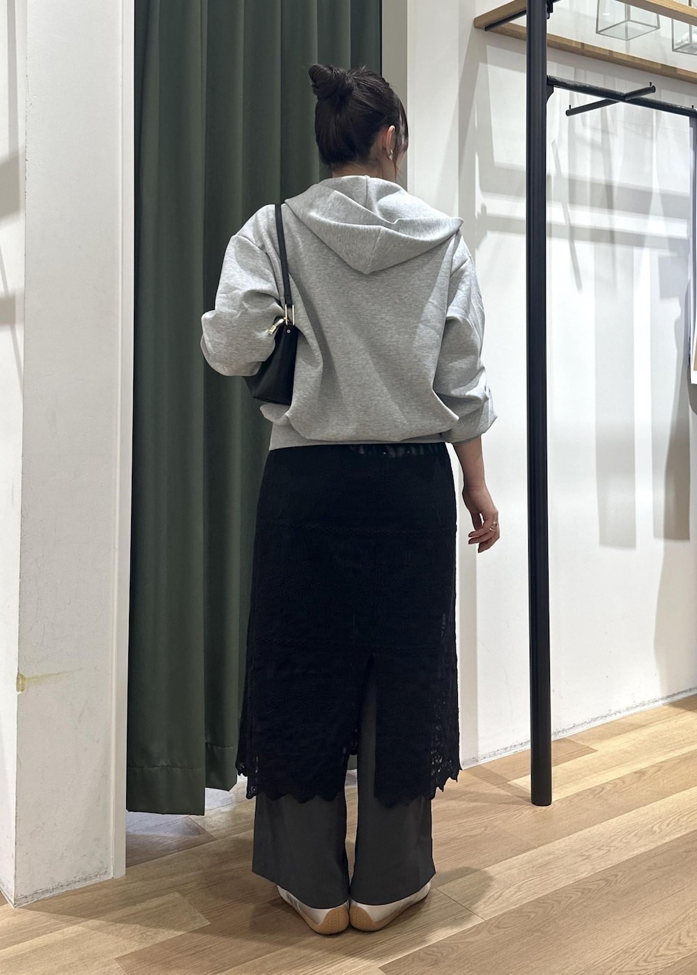 ブラック系のショルダーバッグ、ブラック系のワンピース、ホワイト系のTシャツ/カットソーを着用したレディースの春コーディネートの5枚目の写真