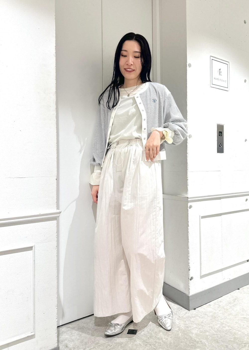 ベージュ系のその他パンツ、ホワイト系のカーディガン/ボレロ、ホワイト系のTシャツ/カットソーを着用したレディースの春コーディネートの2枚目の写真