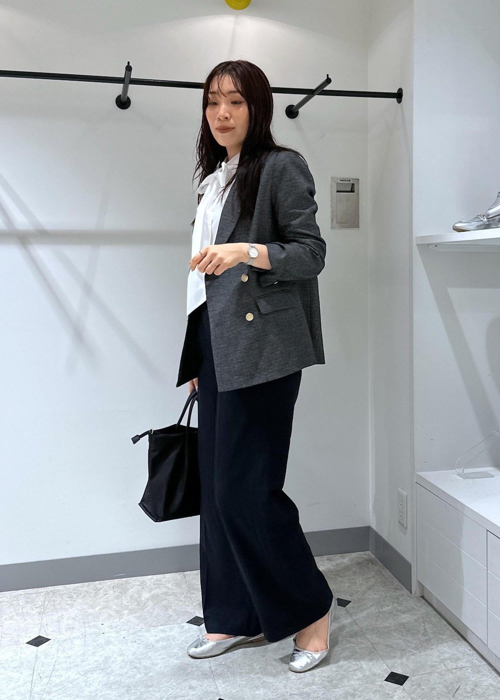 シルバー系のバレエシューズ、ブルー系のシャツ/ブラウス、ブラック系のショルダーバッグを着用したレディースの夏コーディネートの3枚目の写真