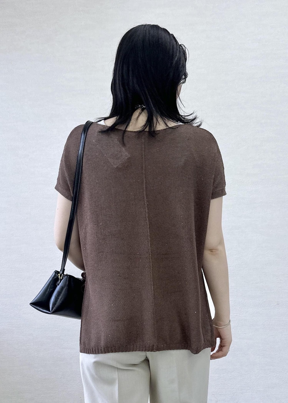 ベージュ系のその他パンツ、ブラック系のショルダーバッグ、イエロー系のニット/セーターを着用したレディースの夏コーディネートの7枚目の写真