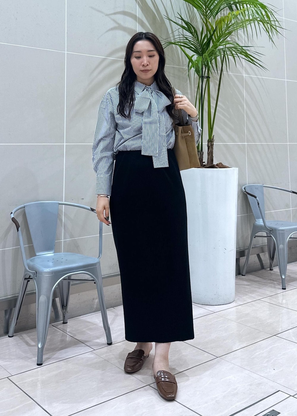 イエロー系のローファー、イエロー系のトートバッグ、ブルー系のシャツ/ブラウスを着用したレディースの秋コーディネートの3枚目の写真