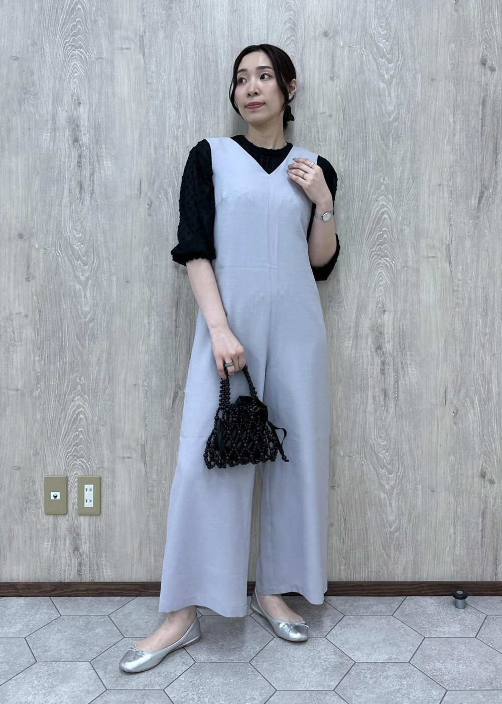シルバー系のバレエシューズ、ブラック系のハンドバッグ、グレー系のつなぎ/オールインワンを着用したレディースの春コーディネートの3枚目の写真