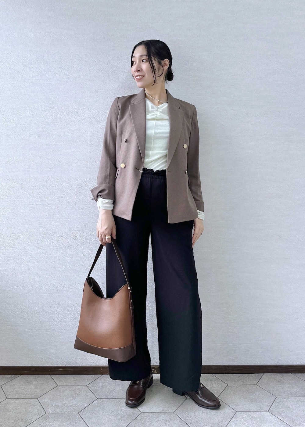 ブラック系のその他パンツ、ホワイト系のTシャツ/カットソー、ベージュ系のテーラードジャケットを着用したレディースの秋コーディネートの2枚目の写真