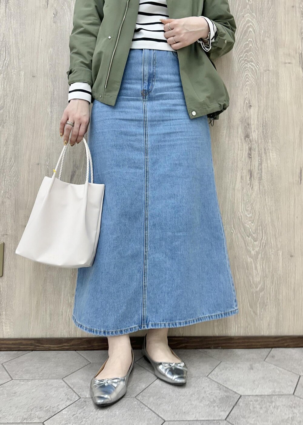 グリーン系のマウンテンパーカー、ホワイト系のTシャツ/カットソー、ブルー系のデニムスカートを着用したレディースの春コーディネートの4枚目の写真