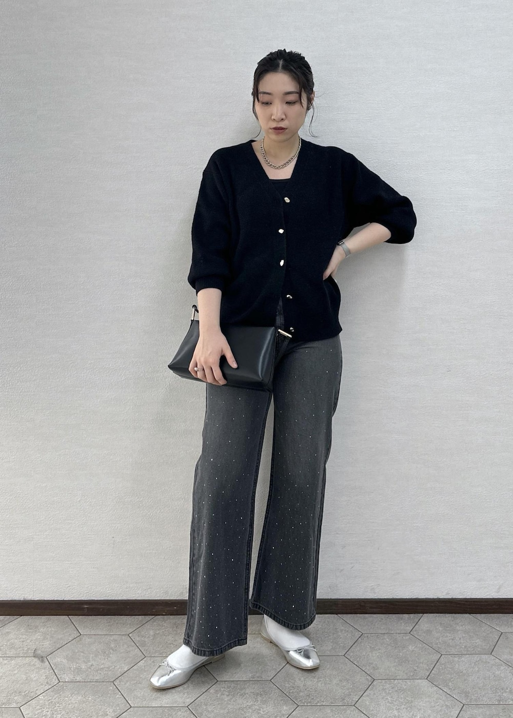 シルバー系のバレエシューズ、ブラック系のデニムパンツ、ブラック系のショルダーバッグを着用したレディースの冬コーディネートの2枚目の写真