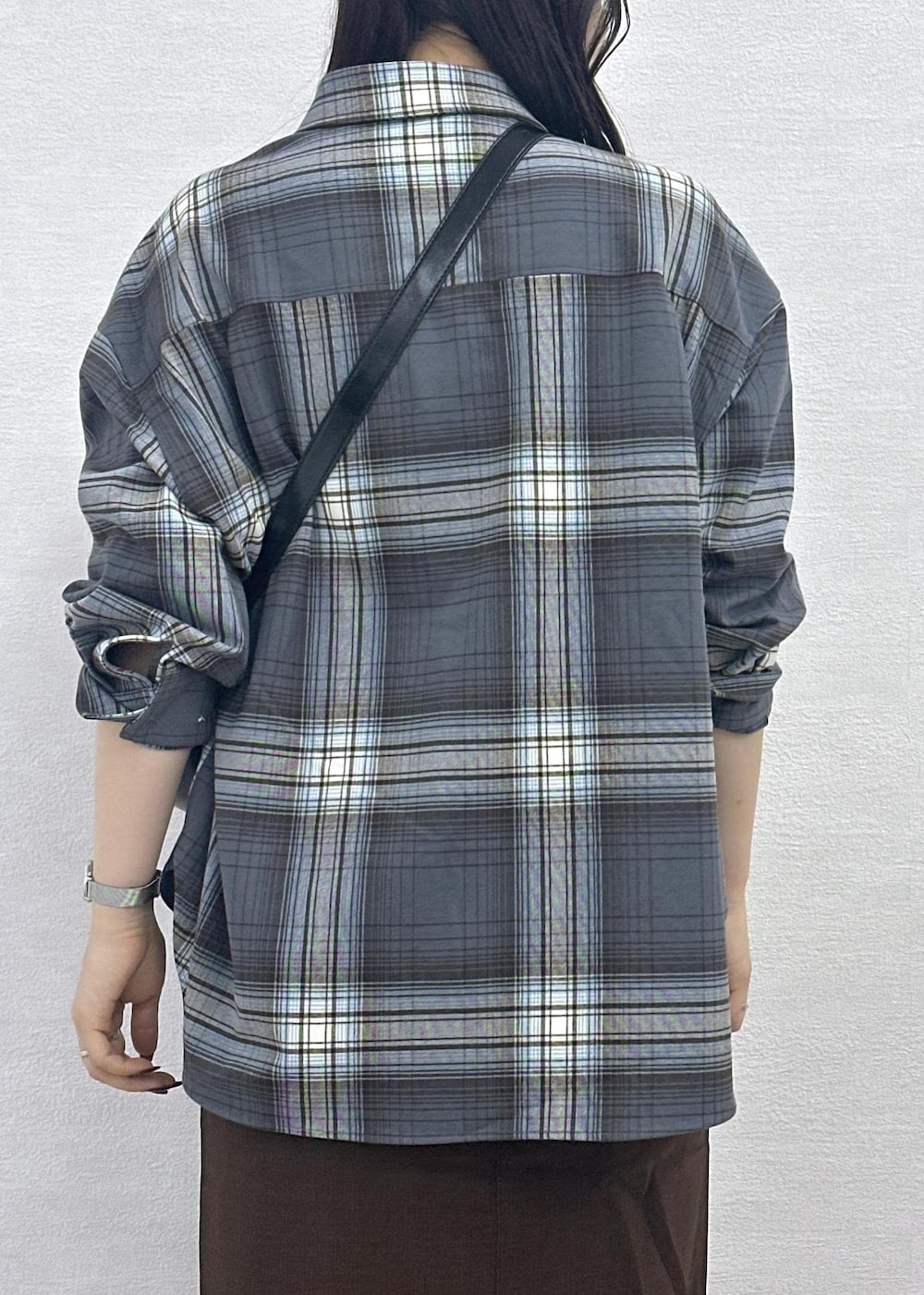 ブラウン系のスカート、ブラック系のショルダーバッグ、グレー系のシャツ/ブラウスを着用したレディースの秋コーディネートの9枚目の写真