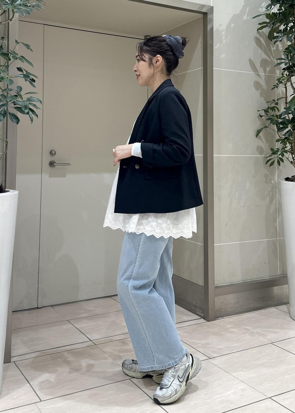 ブルー系のデニムパンツ、ブラック系のショルダーバッグ、ブルー系のテーラードジャケットを着用したレディースの冬コーディネートの3枚目の写真