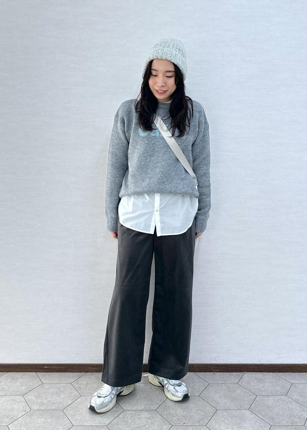 グレー系のニット/セーター、グレー系のその他パンツ、ホワイト系のトートバッグを着用したレディースの冬コーディネートの2枚目の写真