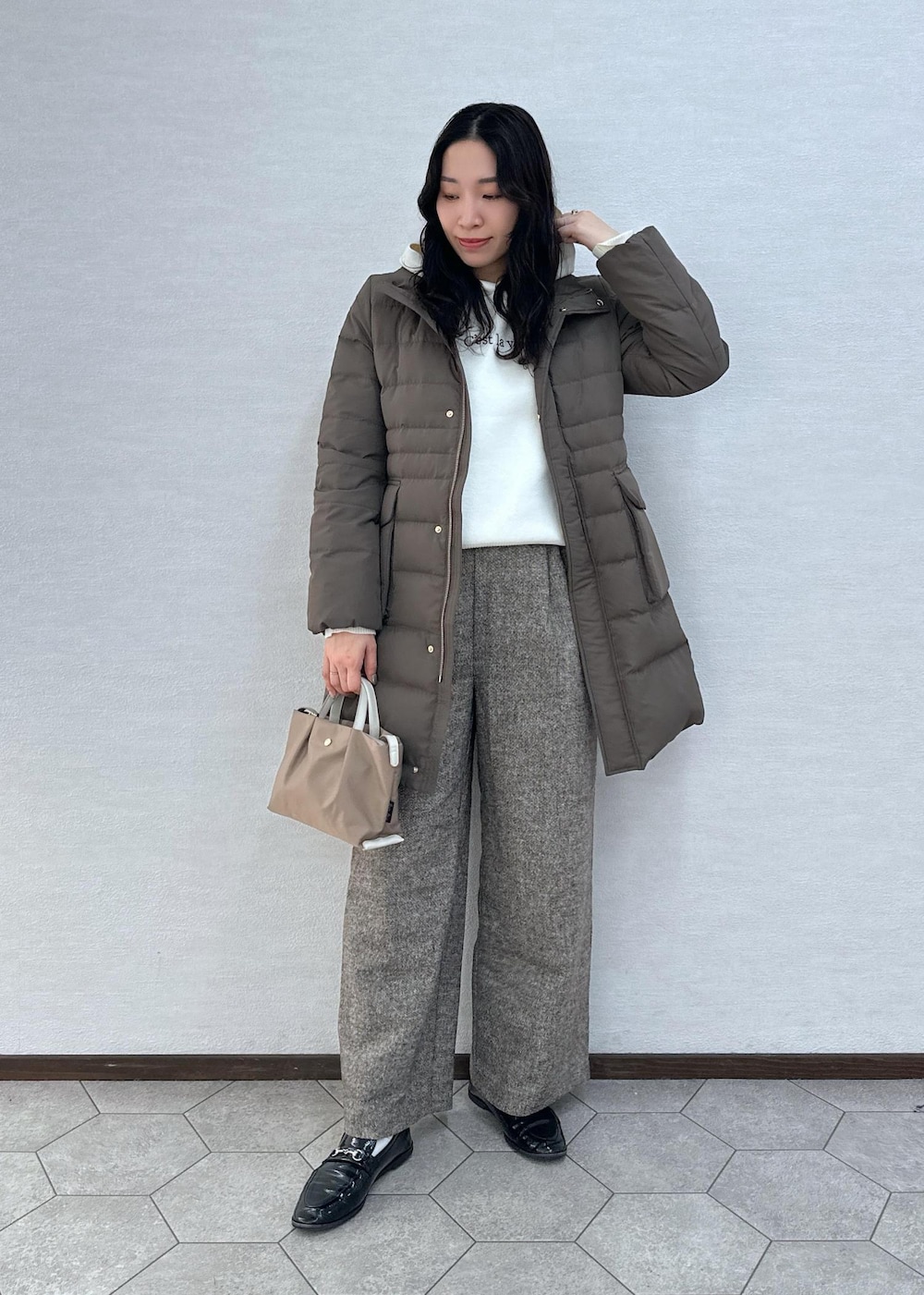 ブラウン系のダウンジャケット/コート、ブラウン系のその他パンツ、ブラウン系のショルダーバッグを着用したレディースの冬コーディネートの2枚目の写真