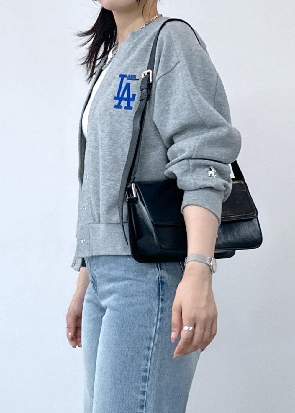 グレー系のデニムパンツ、ホワイト系のタンクトップ、ブラック系のショルダーバッグを着用したレディースの夏コーディネートの9枚目の写真