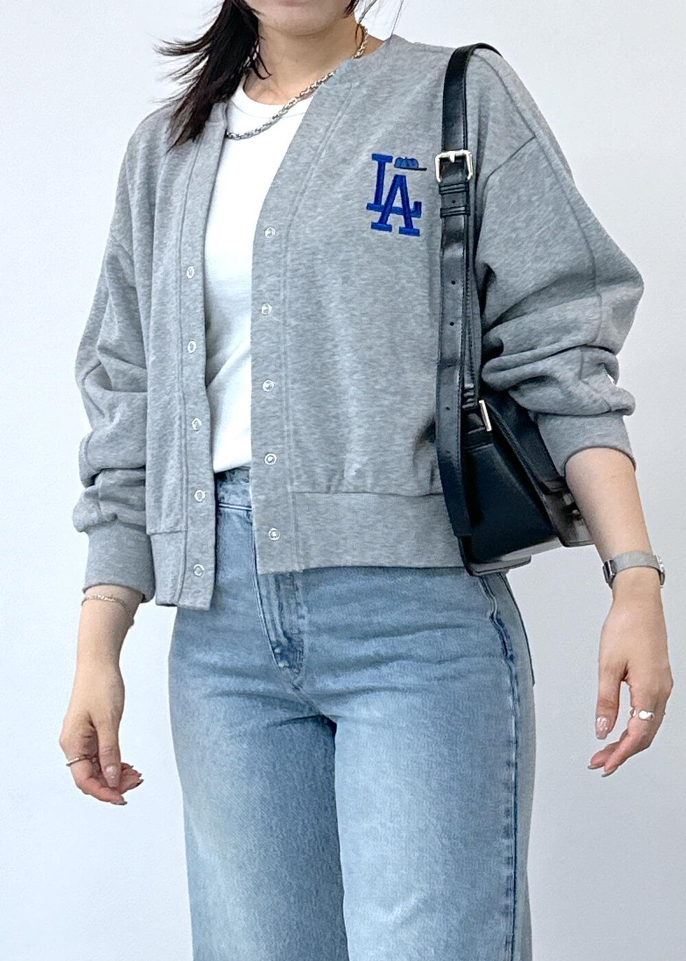 グレー系のデニムパンツ、ホワイト系のタンクトップ、ブラック系のショルダーバッグを着用したレディースの夏コーディネートの8枚目の写真