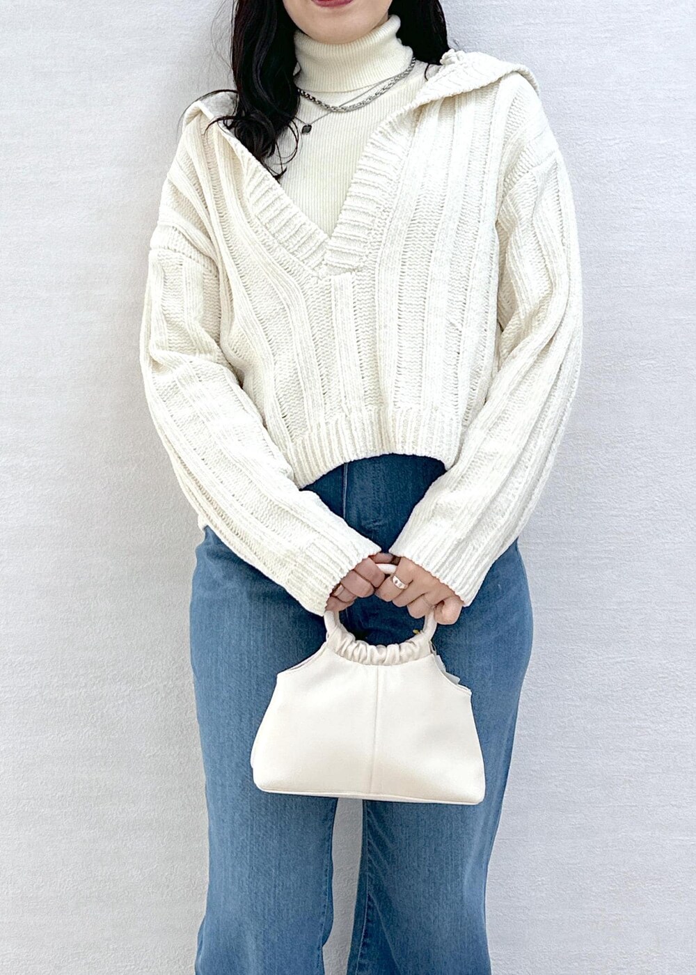 ホワイト系のニット/セーター、ホワイト系のニット/セーター、ブルー系のデニムパンツを着用したレディースの冬コーディネートの6枚目の写真