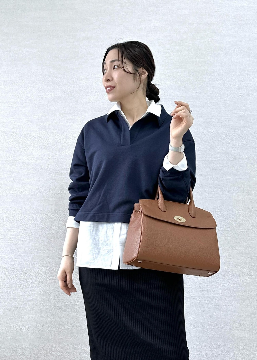 ブラック系のスカート、イエロー系のトートバッグ、ブルー系のスウェットを着用したレディースの春コーディネートの6枚目の写真