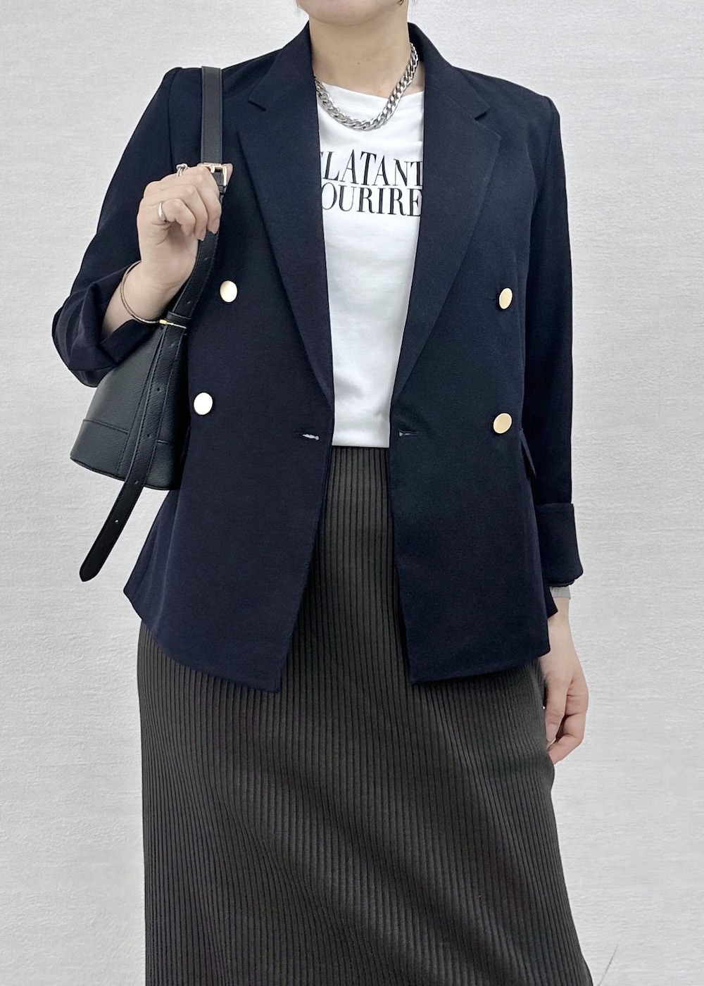 ホワイト系のTシャツ/カットソー、グレー系のスカート、ブラック系のショルダーバッグを着用したレディースの秋コーディネートの6枚目の写真