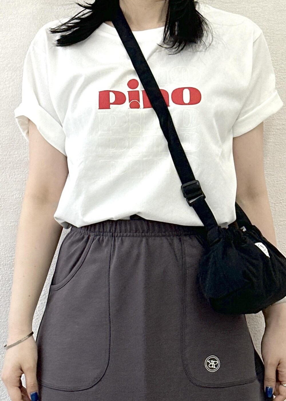 ブラック系のショルダーバッグ、グレー系のスカート、ブラック系のサンダルを着用したレディースの春コーディネートの5枚目の写真