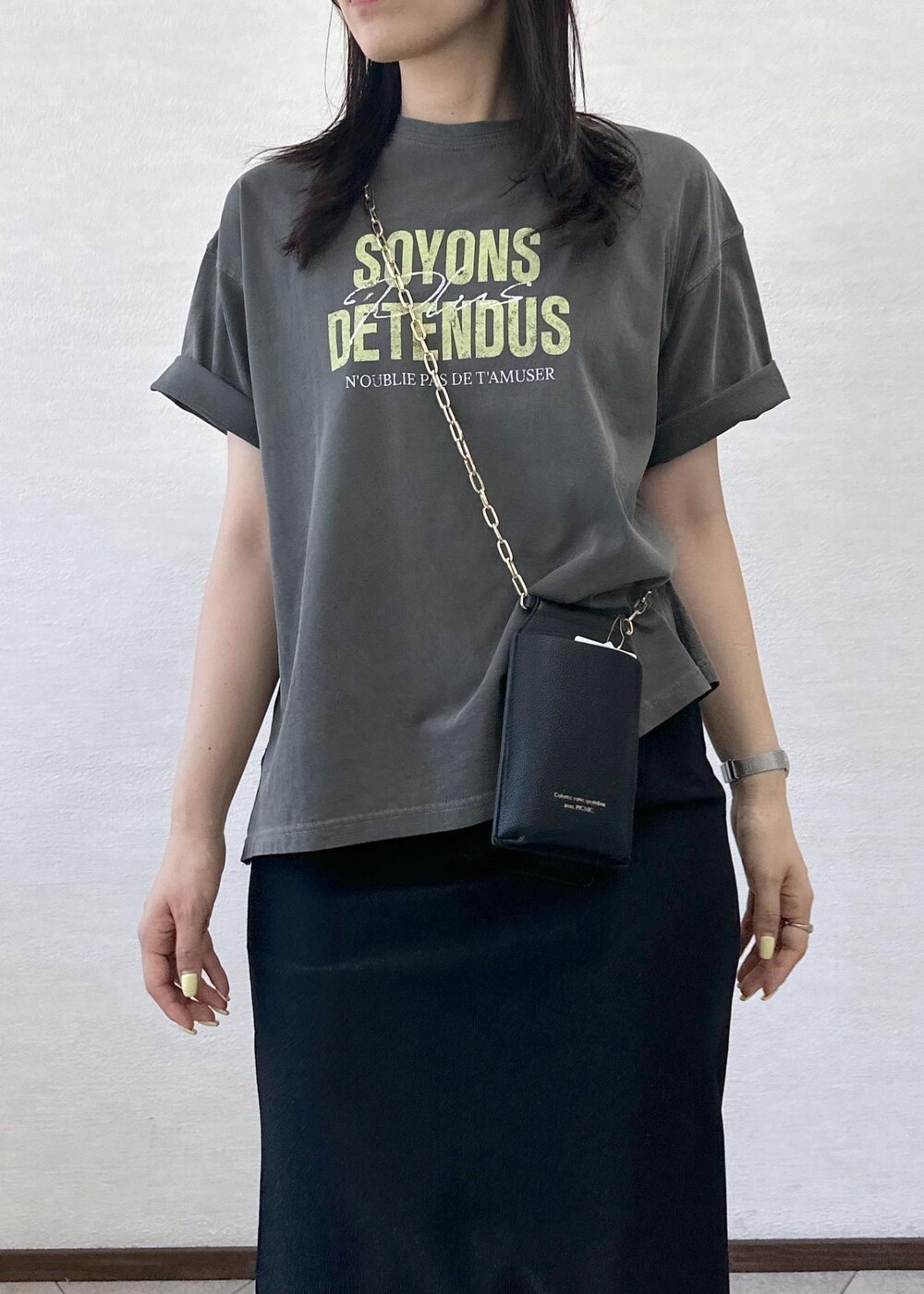 ブラック系のスカート、グレー系のTシャツ/カットソー、ブラック系のショルダーバッグを着用したレディースの夏コーディネートの5枚目の写真