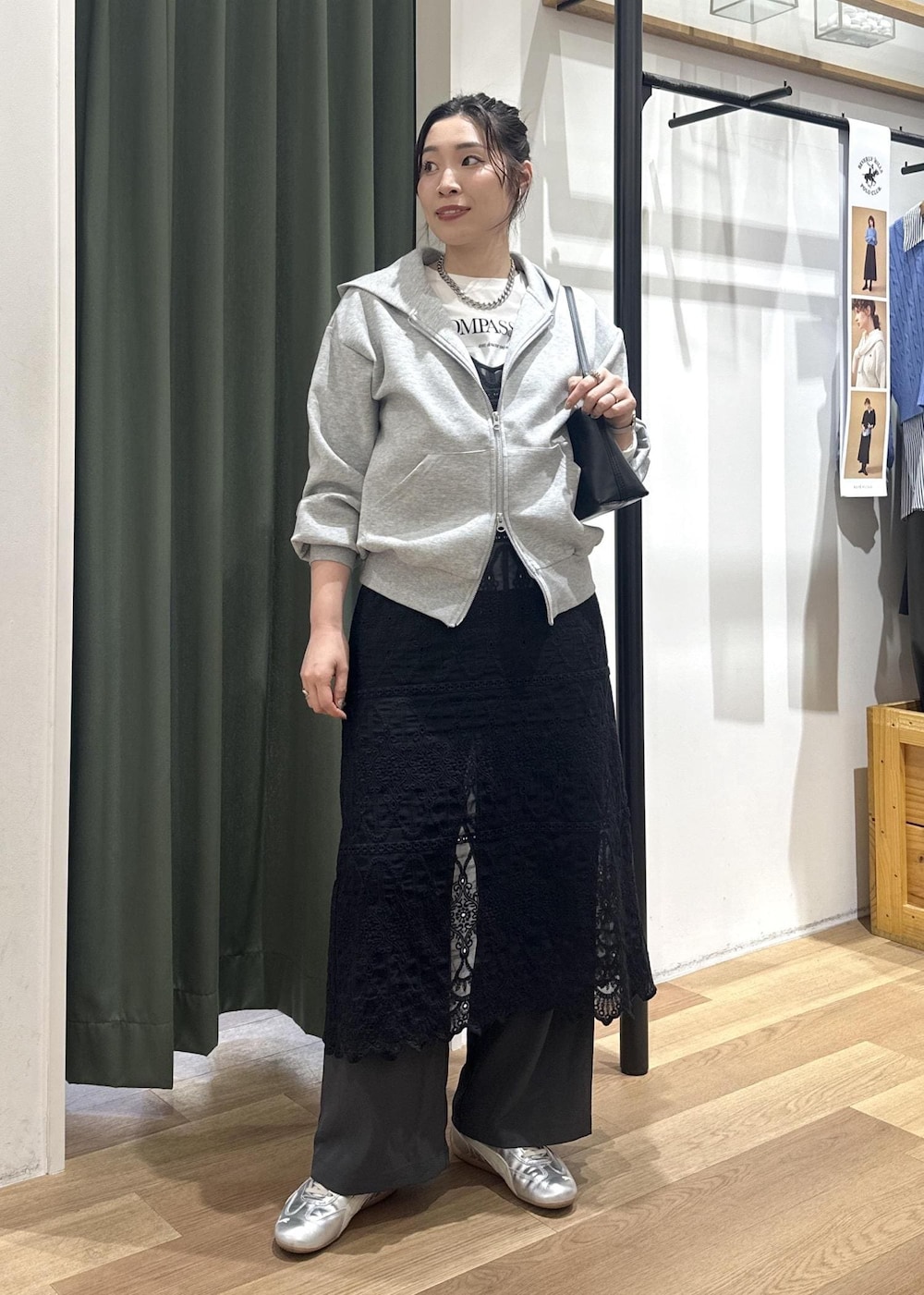 ブラック系のショルダーバッグ、ブラック系のワンピース、ホワイト系のTシャツ/カットソーを着用したレディースの春コーディネートの2枚目の写真