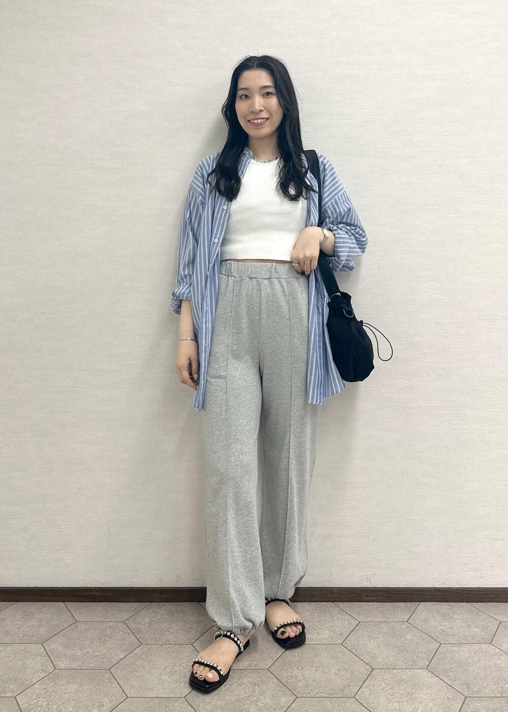 ブラック系のサンダル、ブラック系のショルダーバッグ、ホワイト系のタンクトップを着用したレディースの春コーディネートの2枚目の写真