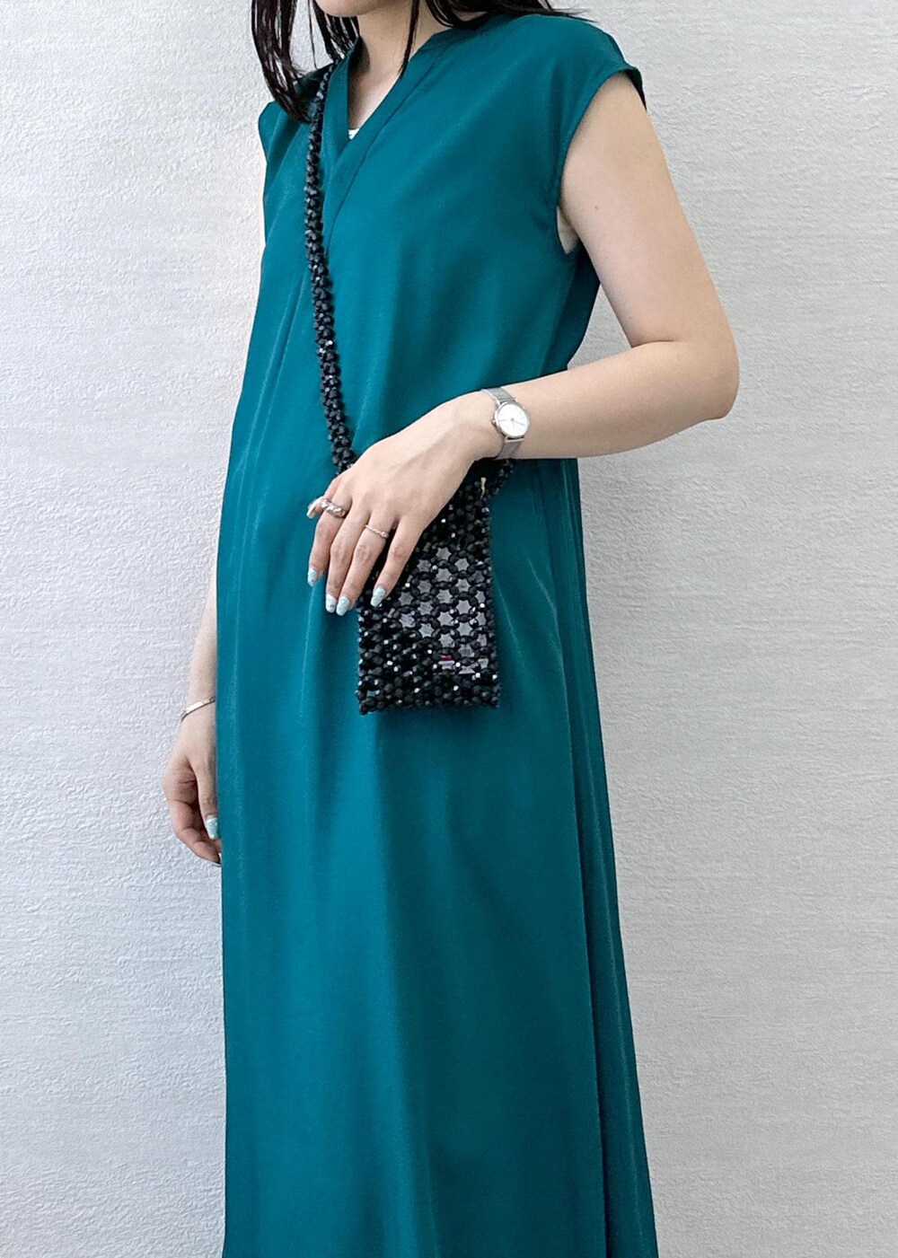 ブラック系のショルダーバッグ、ブルー系のデニムパンツ、グリーン系のワンピースを着用したレディースの夏コーディネートの7枚目の写真