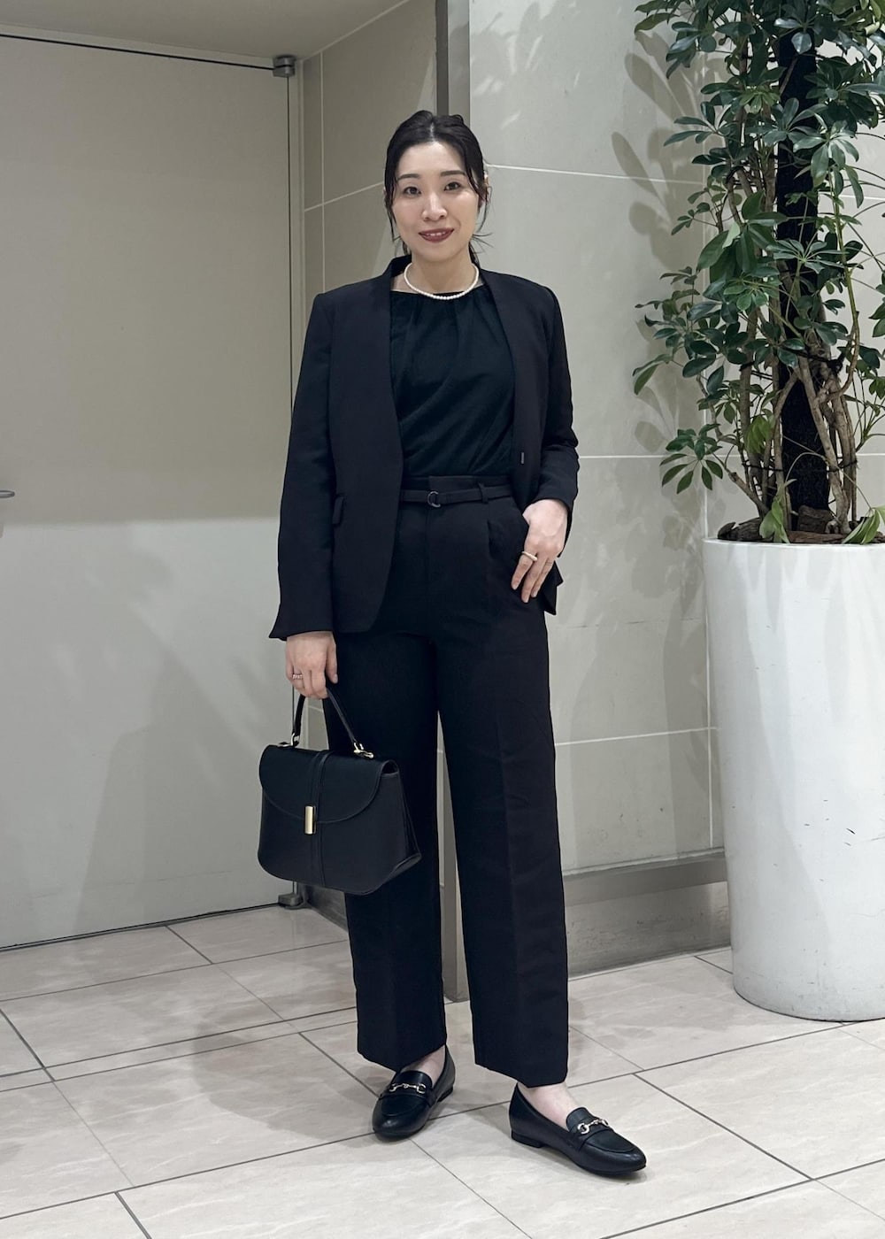 ブラック系のニット/セーター、ブラック系のローファー、ブラック系のノーカラージャケットを着用したレディースの冬コーディネートの2枚目の写真