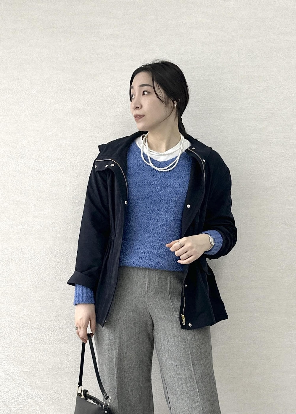 ブラック系のショルダーバッグ、ブルー系のニット/セーター、グレー系のその他パンツを着用したレディースの春コーディネートの7枚目の写真