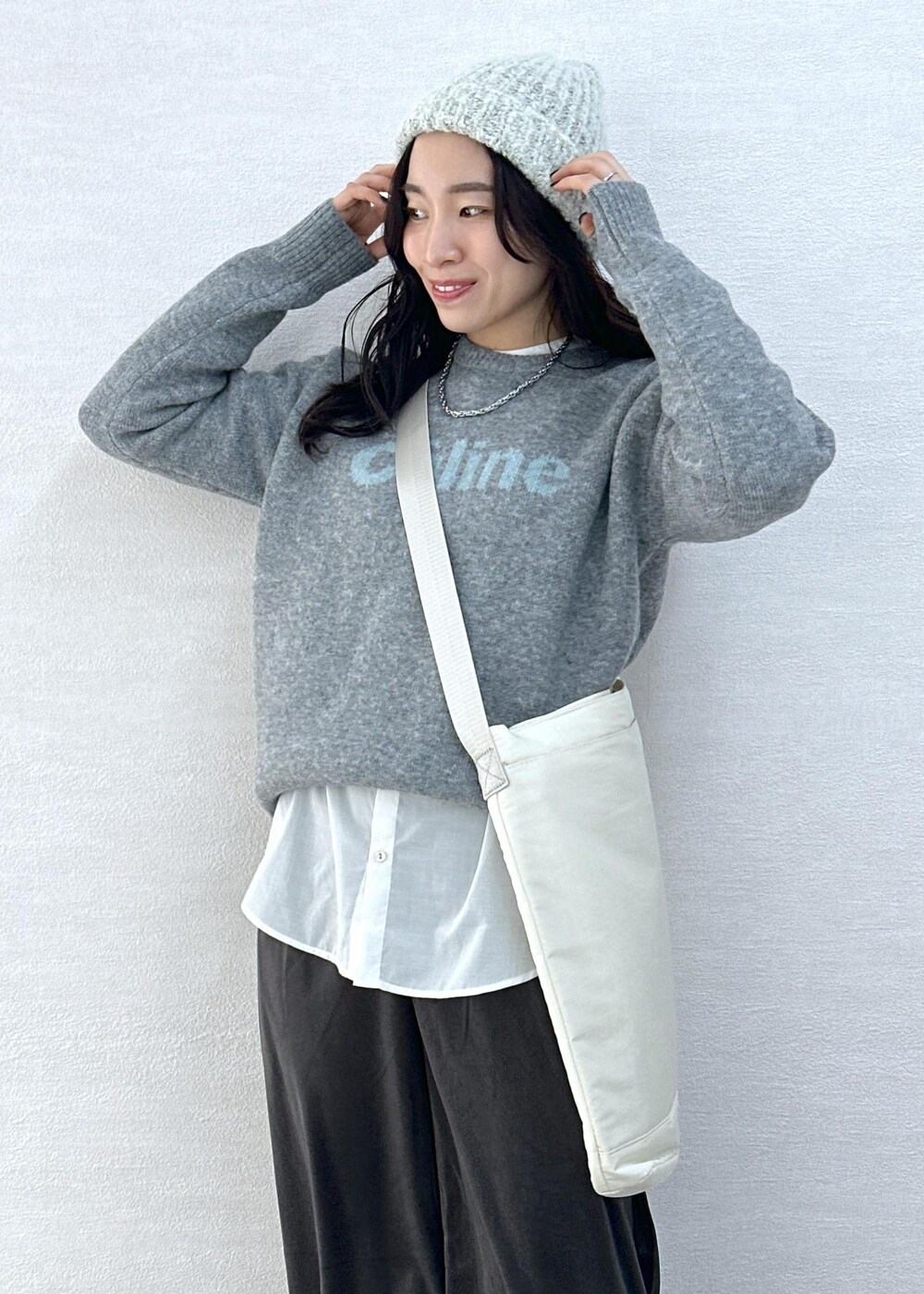 グレー系のニット/セーター、グレー系のその他パンツ、ホワイト系のトートバッグを着用したレディースの冬コーディネートの7枚目の写真