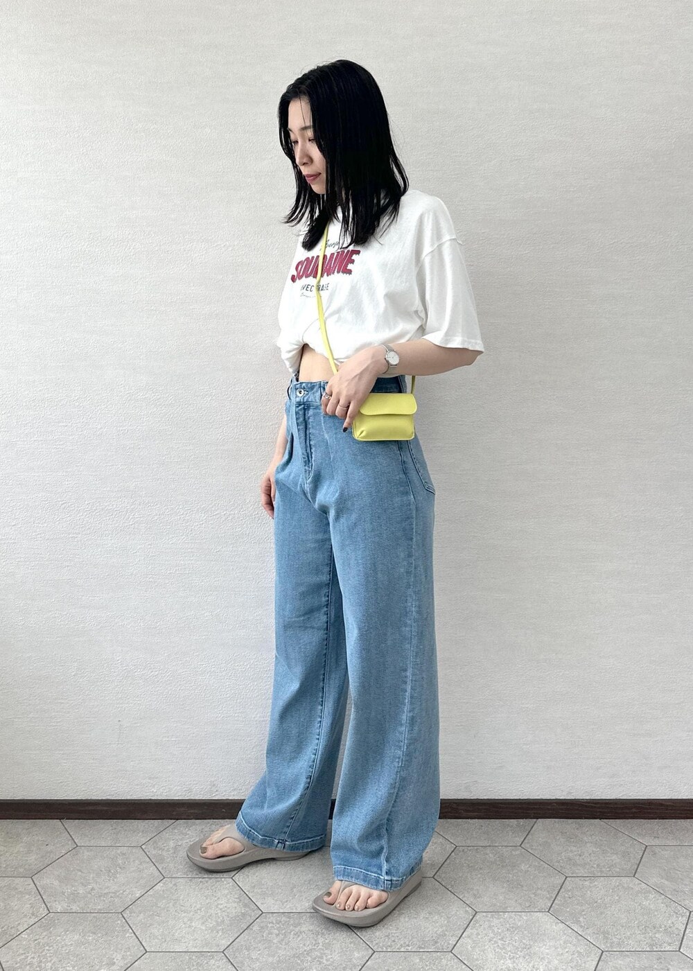 イエロー系のショルダーバッグ、ブルー系のデニムパンツ、ホワイト系のTシャツ/カットソーを着用したレディースの夏コーディネートの3枚目の写真