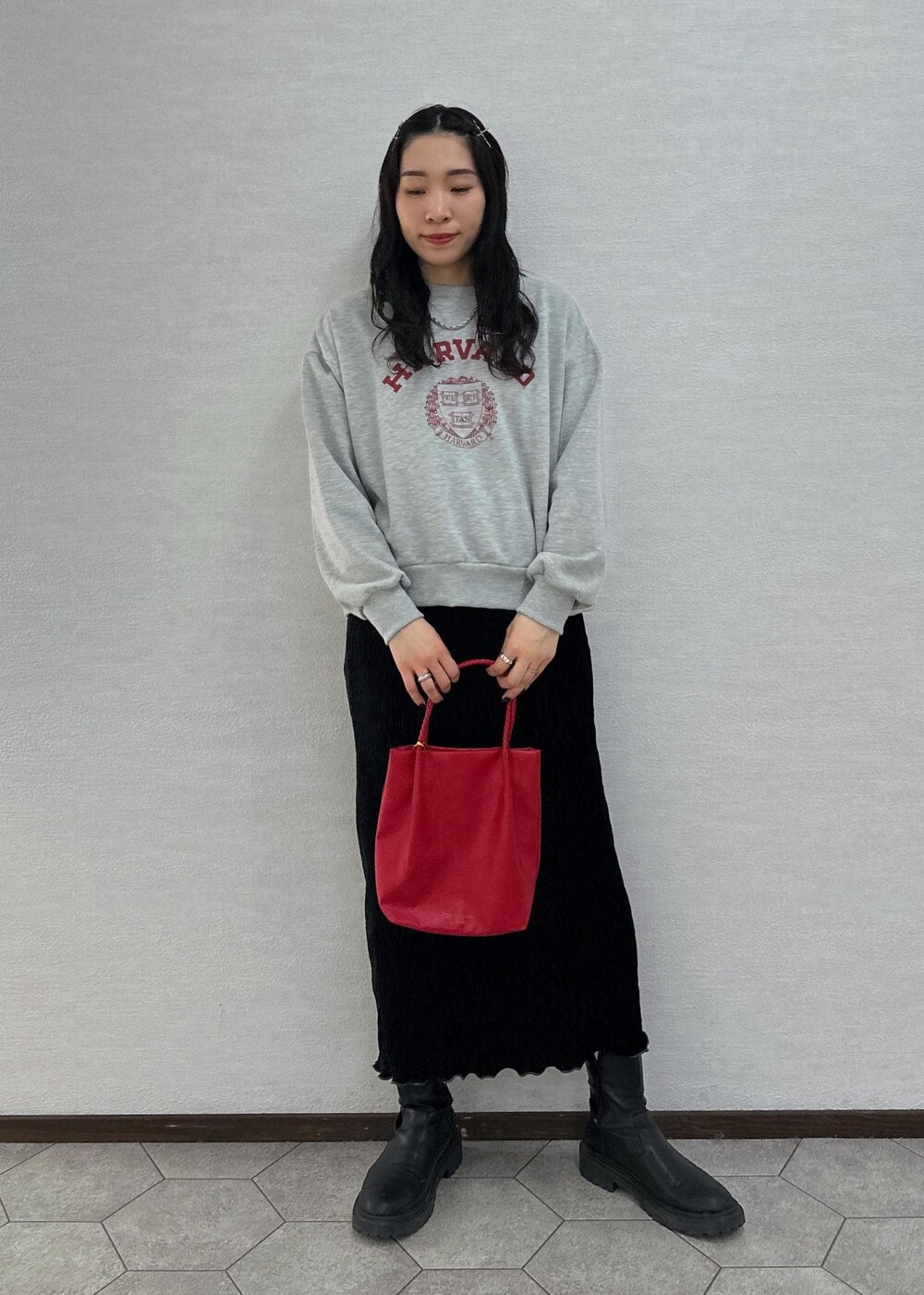 グレー系のスウェット、レッド系のトートバッグ、ブラック系のスカートを着用したレディースの冬コーディネートの3枚目の写真