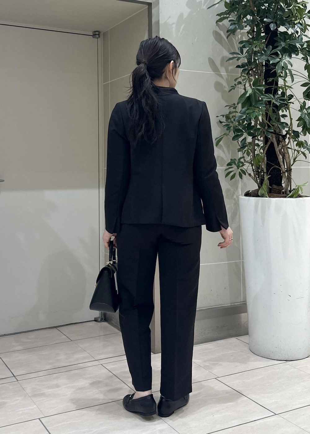 ブラック系のニット/セーター、ブラック系のローファー、ブラック系のノーカラージャケットを着用したレディースの冬コーディネートの5枚目の写真