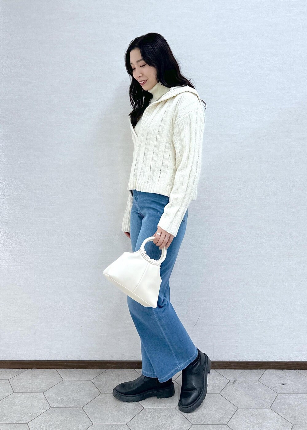ホワイト系のニット/セーター、ホワイト系のニット/セーター、ブルー系のデニムパンツを着用したレディースの冬コーディネートの3枚目の写真