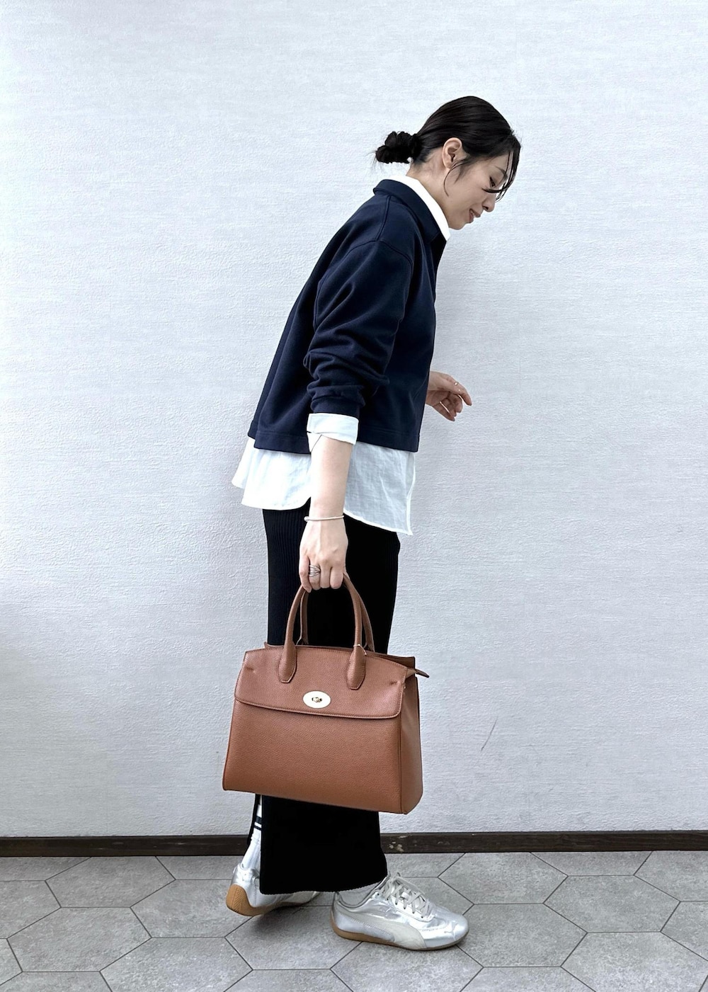 ブラック系のスカート、イエロー系のトートバッグ、ブルー系のスウェットを着用したレディースの春コーディネートの5枚目の写真